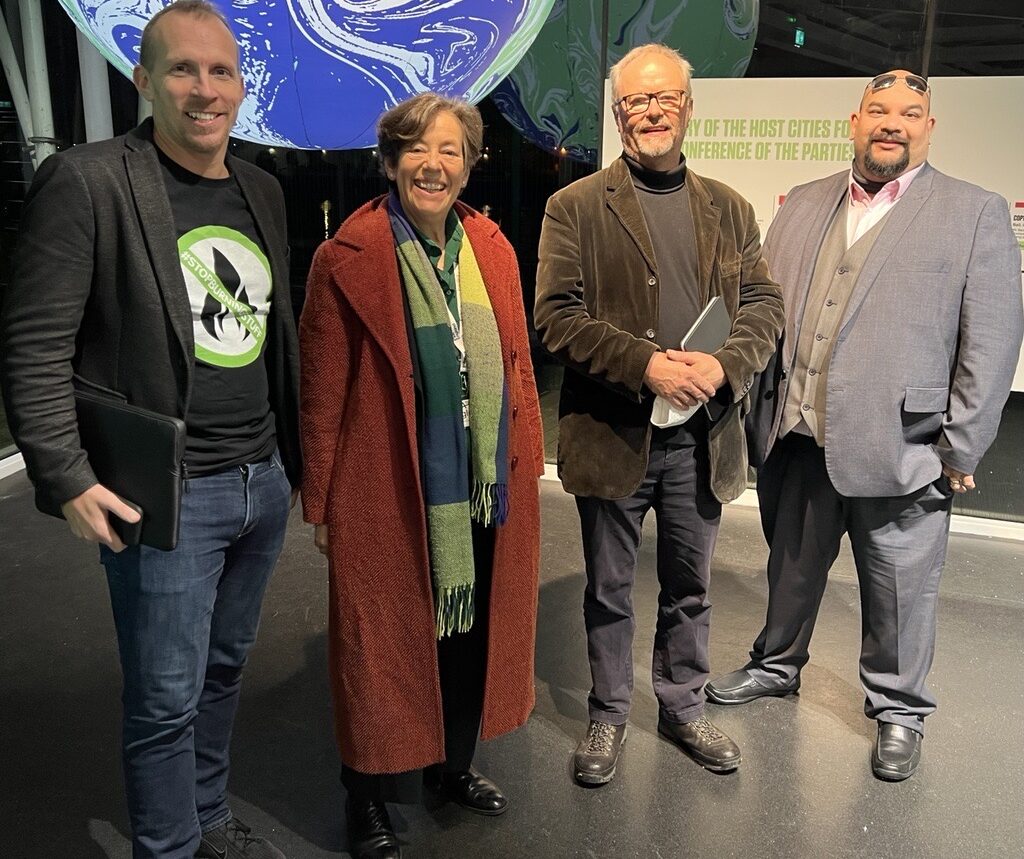 Dan Caeser (Fully Charged joint CEO), Bridget Phelps (outgoing Chair EVA England), Robert Llewellyn (Fully Charged joint CEO), Warren Philips (New Chairman EVA England) at COP26.