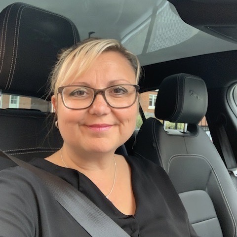 A portrait of Michelle, from Women Drive Electric, in her EV