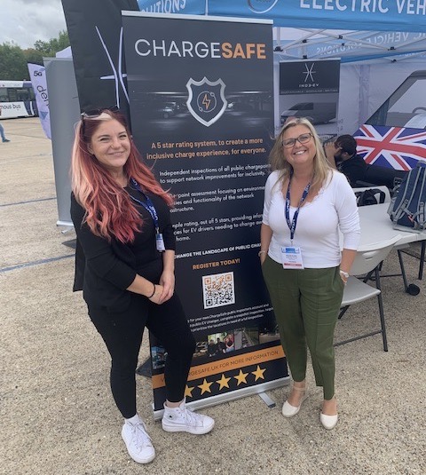 Michelle, standing with Kate Tyrell in front of a banner for ChargeSafe
