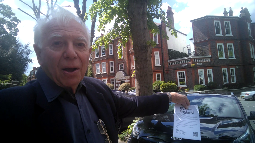 Alan Cooklin standing in front of his EV and holding the certificate of incorporation: EVA England's funding on paper!